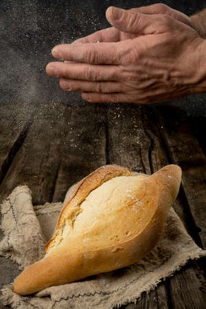 Freshly backed farmhouse bread on an old rustic wooden board. Retro styleの写真素材