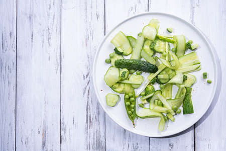 Summer green pea salad of cucumbers and pea on a whiteの写真素材