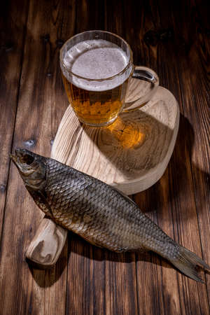 Beer with dried fish and snacks on wooden table.の写真素材