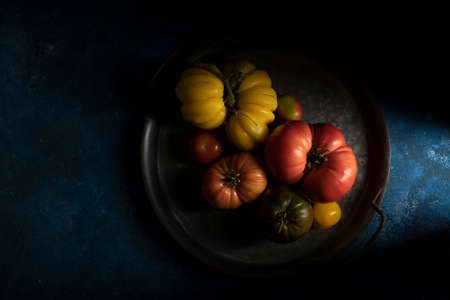 Set of ripe tomatoes in the tray, blue wooden backgroundの写真素材