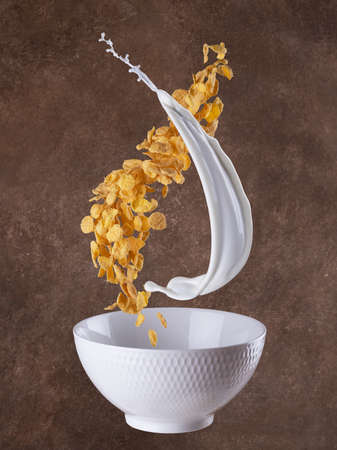 splashes of milk, cornflakes and granola. Levitation on brown backround