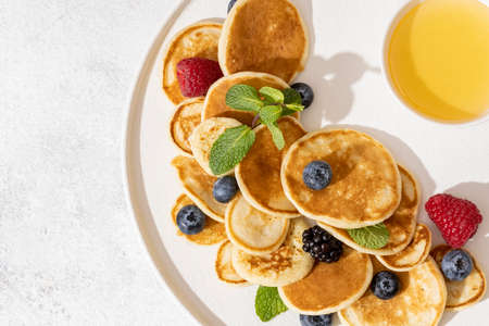 tasty pancakes and berries on white plate.の写真素材