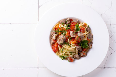 pasta with tomato sauce and meat on white plate and white ceramic bacground. Top viewの写真素材