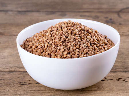 buckwheat in a white plate on a wooden backgroundのeditorial素材