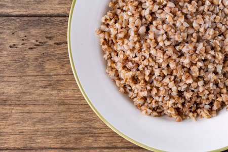 buckwheat in a white plate on a wooden backgroundのeditorial素材