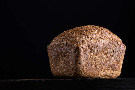 loaf of rye homemade bread in dark background.