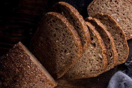 Bread, traditional homemade bread cut into slices on a rustic wooden background, close-up