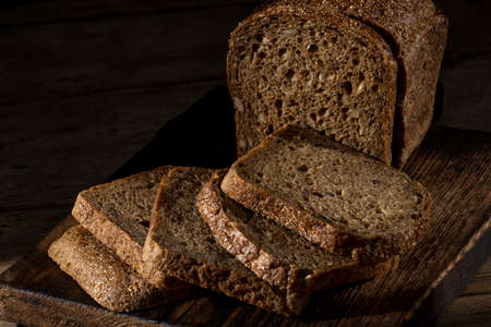 Bread, traditional homemade bread cut into slices on a rustic wooden background, close-up