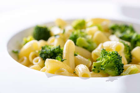 pasta with broccoli on a white plate and white ceramic background.の写真素材