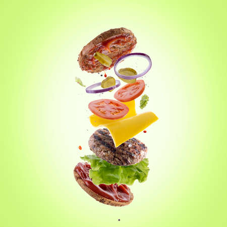Burger with flying elements. Delicious burger with flying ingredients. Flying Burger Slicesの写真素材
