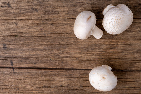 Fresh raw organic champignons heap on a wooden tableの写真素材
