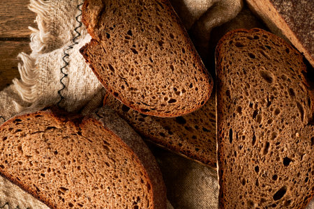 Bread, traditional homemade bread cut into slices on a rustic wooden background, close-up