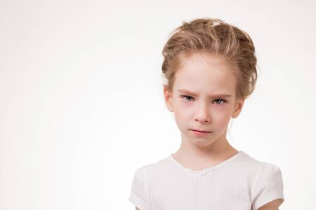 Cute teen girl angry frowns, studio portrait isolated on white background.の写真素材