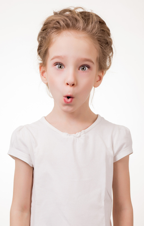 Portrait of surprised excited girl covering her mouth by the hand. Isolated on white background.の写真素材