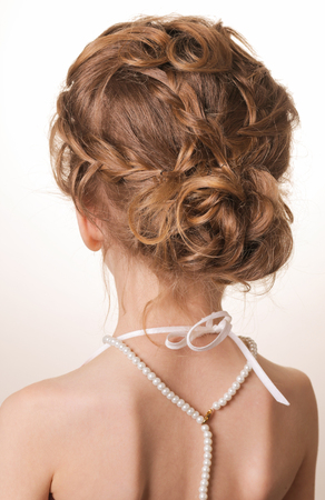 Portrait of young beautiful teen girl with blond hair and braid hairdo. Rear view, hairstyle with tressの写真素材