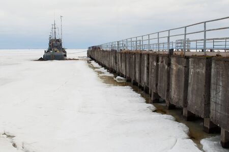 photo on the winter waterfront with ship in iceの写真素材