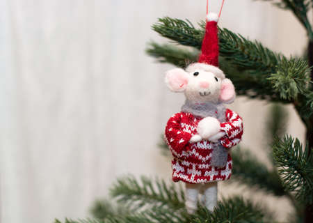 Christmas toy rat on the background of a Christmas tree. Christmas greeting card.の写真素材