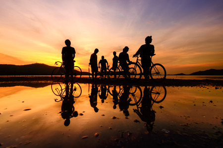 Silhouette cyclists with reflectionの写真素材