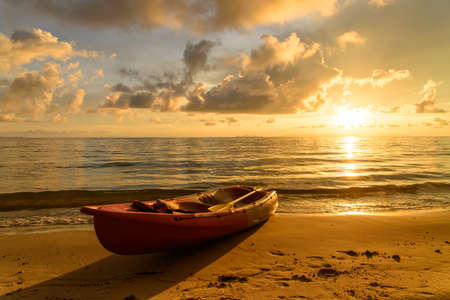 Kayak on a beach at sunsetの写真素材