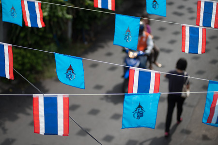 BANGKOK, THAILAND - SEPTERMBER 11, 2014 : Flag of Queen Sirikit of Thailand decorated alongside Thai national flag above a street in Bangkok.のeditorial素材