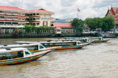 BANGKOK - JUNE 30, 2015: Sightseeing boats waiting for tourists on Chao Phraya river.のeditorial素材