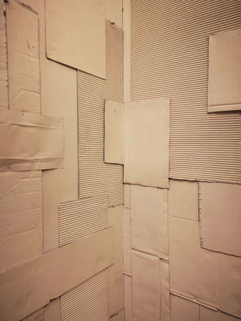 Background and Different texture of the old corrugated cardboard on the wall with corner and perspective. Layer of brown packing and recycle paper. Scrap and patch of corrugated paperboard, copy spaceの写真素材