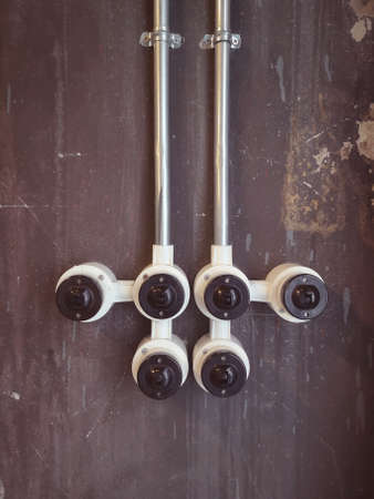 Rustic and Vintage Electrical : Set of light switches with steel pipe on the grey dirty cement wall in studio of buildingの写真素材