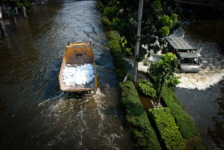BANGKOK - NOVEMBER 7 2011: Heavy supplies truck is driven through water after impact with heaviest flood and rain in 20 years in the capital on November 07, 2011 in Bangkok, Thailand.のeditorial素材