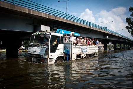 BANGKOK - NOVEMBER 7 2011: Large truck carried flood victims after impact with heaviest flood and...