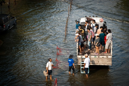 BANGKOK - NOVEMBER 7 2011: Victims of flood walked toward the free transportation  after impact with heaviest flood and rain in 20 years in the capital on November 07, 2011 in Bangkok, Thailand.のeditorial素材