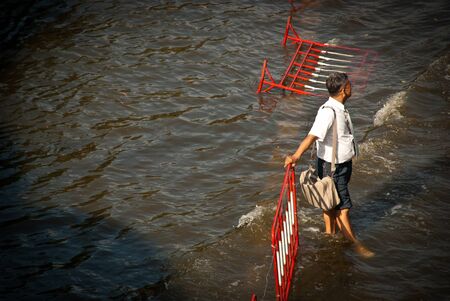 BANGKOK - NOVEMBER 7 2011: A man waited for free transport after impact with heaviest flood and rain in 20 years in the capital on November 07, 2011 in Bangkok, Thailand.のeditorial素材