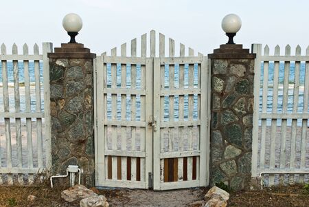 Closed door to open sea, displaying a concept of constraints on freedomの写真素材