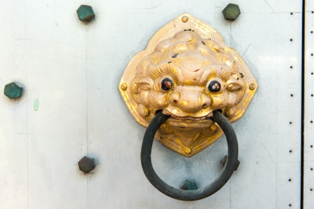 Chinese temple golden door handle, on a grey metal doorの写真素材