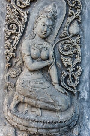 Ancient old vintage buddha sculpture on the wall, taken on a sunny dayのeditorial素材