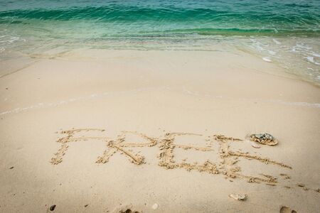 Beach on gulf of Thailand with word Free written on the sand, taken on a sunny dayの写真素材