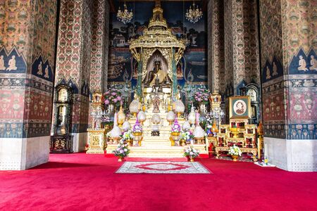 Tradtional buddha golden praying set complete with flowers, taken indoor in public templeのeditorial素材