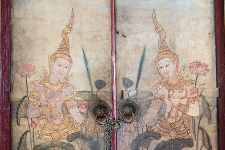Very old vintage door with Buddha gods painting on it, take on a cloudy dayのeditorial素材