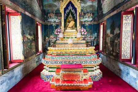 Tradtional buddha golden praying set complete with flowers, taken indoor in public templeのeditorial素材