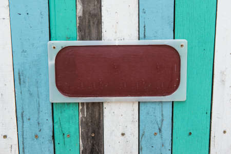 Blue, white, black contrasting old wooden texture background with metal sign, taken on a sunny dayの写真素材