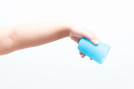 Asian woman holding a small plastic cup, isolatedの写真素材