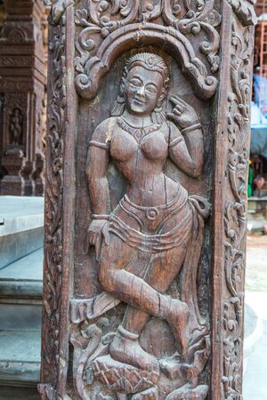 Ancient wooden art scuplture with detail design of ancient asian myth, taken outdoor on a sunny dayの写真素材