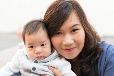 Thai baby male infant with his Thai mother, taken outdoor