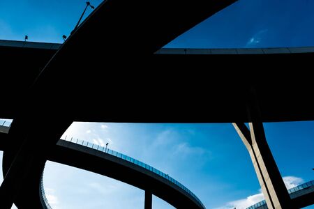 Silhouette of highway ramps on a sunny day, useful for construction, engineering, transportation, building, industrial conceptsの写真素材