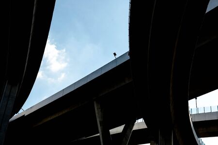 Silhouette of highway ramps on a sunny day, useful for construction, engineering, transportation, building, industrial conceptsの写真素材