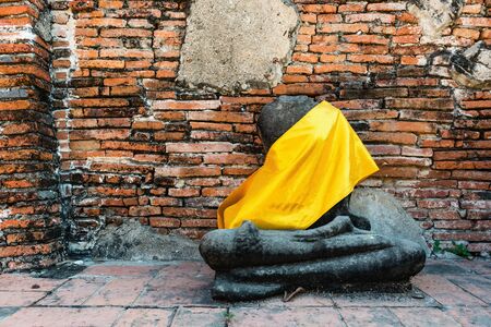Broken buddha statue, taken outdooor in afternoon, useful for religious and faith conceptsの写真素材