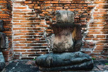 Broken buddha statue, taken outdooor in afternoon, useful for religious and faith conceptsの写真素材