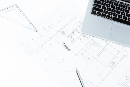 Pen, drawing rulers, and notebook over house construction blueprint with blue tone effect, useful for construction, business, architecture, engineering, insurance background conceptsの写真素材