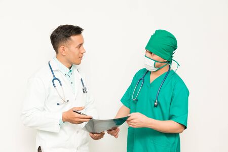 Asian male medical doctors with xray film on white background, useful for medical, hospital, medication, surgent, medical advise, doctor, health care conceptsの写真素材