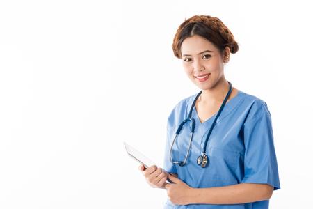 Female Asian nurse using a digital tablet & wearing a blue coat on white background, useful for digital health care, digital medical care, ehospital, e-medication conceptsの写真素材