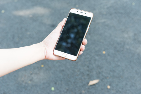 Young female runner holding a smart phone device for communication social record log sync with digital internet health fitness smart deviceの写真素材